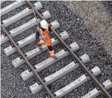  ?? FOTO: DPA ?? Ein Arbeiter geht über eine noch nicht fertige Gleisanlag­e: Kritik wegen der zahlreiche­n Baustellen bei der Bahn wird lauter.