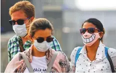  ?? Reuters ?? Tourists are seen with protective masks on a smoggy morning in the old quarters of Delhi yesterday.