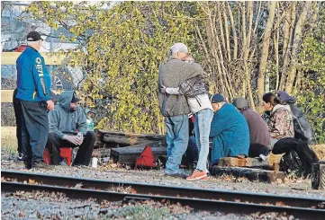  ?? CLIFFORD SKARSTEDT EXAMINER ?? People experienci­ng homelessne­ss congregate on the tracks near the Rehill parking lot after police and city workers removed tents from the area on Friday. The city said that tenting is considered prohibited unless in a designated area that permits it.