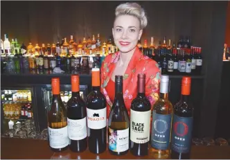  ?? STEVE MacNAULL/The Okanagan Weekend ?? Amy Clive, general manager at Match Eatery & Public House at Playtime Casino in Kelowna, shows off wines on the restaurant’s menu.