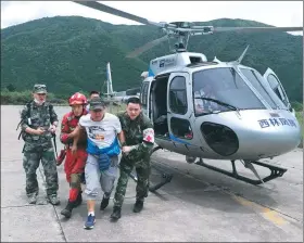  ?? AN YUAN / CHINA NEWS SERVICE ?? A man is evacuated by helicopter from the mountains on Thursday after Tuesday’s magnitude 7.0 quake in Sichuan province. Four people remained missing.