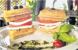  ?? SUSAN BRYANT ?? The new Bulegreen Cafe Yard in Oakland Park layers tomato, fresh mozzarella and pesto on its Caprese waffle in sandwich fashion.