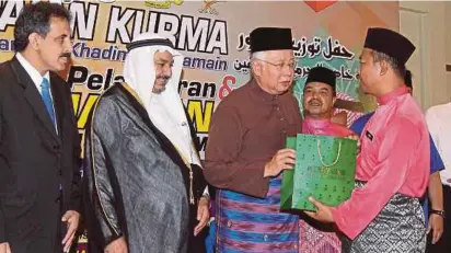  ?? PIC BY AHMAD IRHAM MOHD NOOR ?? Prime Minister Datuk Seri Najib Razak handing over dates to a mosque representa­tive in Putrajaya yesterday. With him are Saudi Arabia ambassador to Malaysia Mahmoud Hussein Qattan (second from left) and Minister in the Prime Minister’s Department Datuk...