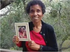  ??  ?? Andrea Gourdine holds a photo of her mother, Gladys Brown, who died in 2012 after being diagnosed with Alzheimer’s. Brown donated her brain to the University of California- Davis for research.