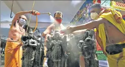  ?? PTI PHOTO ?? Priests disinfect idols at a temple in Bengaluru on Saturday before it reopens. n