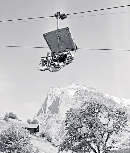  ?? ?? Don’t look down! Tourists ride the Grindelwal­d chair lift in the 1960s
Minty Clinch takes the new Eiger Express cable car earlier this year
Today’s visitors can view the Swiss Alps from a cliff walk platform