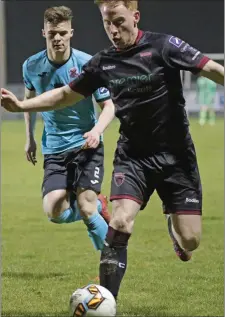  ??  ?? Chris Kenny of Wexford F.C. is watched by Cobh’s Charlie Fleming.