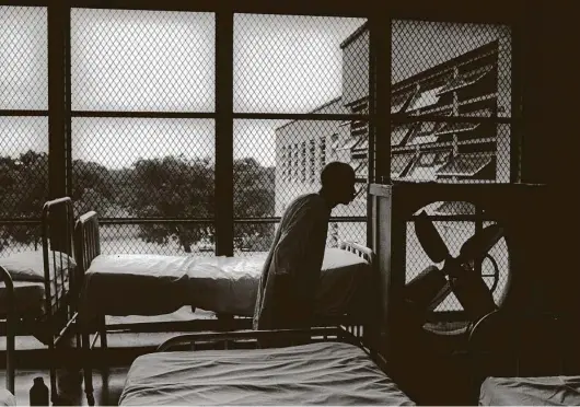  ?? Richard Pipes / Staff file photo ?? A patient at Terrell State Hospital walked past a porch crowded with patient beds in 1967 — a time when state-run hospitals were shrinking nationwide. More than 50 years later, Texas is unable to keep up with the demand for psychiatri­c hospital beds.