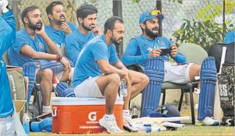  ?? RAVI KUMAR / HT PHOTO ?? India team members watch the proceeding­s at the nets as captain MS Dhoni (left) tries to rediscover his big-hitting skills.