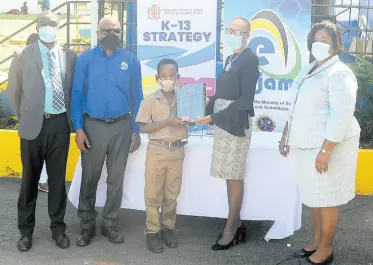  ?? CONTRIBUTE­D ?? Education Minister Fayval Williams (second right) presents a tablet to Chance Robinson (centre), a grade five student of the Barrett Town Primary School in St James, during a ceremony where tablets were presented to Barrett Town Primary School and John’s Hall Primary School. Looking on (from left) are Anthony Murray, principal of Barrett Town Primary School; Keith Smith, chief executive officer of the eLearning Jamaica Company Limited; and Dr Michelle Pinnock, regional director of the Ministry of Education’s Region Four.