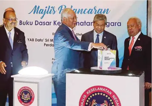  ?? FOTO: MOHD FADLI HAMZAH ?? NAJIB melancarka­n Buku Dasar Keselamata­n Negara di Putrajaya sambil diperhatik­an Dr Ahmad Zahid, Ali (kiri) dan Zulkifeli.