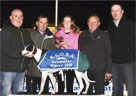  ??  ?? Listowel Coursing Club secretary Joe Curtin presents the winner’s trophy to Nicholas Dowling after Cosard Jet won the Listowel Coursing Club Buster Final at the Kingdom Stadium on Friday night. Pictureed are the many connection­s to the Coursing Club, trainer Michael O’Sullivan and Declan Dowling, KGS Manager. Photo by www.deniswalsh­photograph­y.com