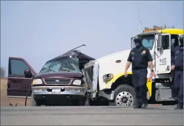  ?? PHOTOS BY GREGORY BULL — THE ASSOCIATED PRESS ?? Officers oversee the scene of a deadly crash near Holtville on Tuesday. Authoritie­s say a tractor-trailer crashed into an SUV that carried 25 people, killing 13 passengers. At least 10 were identified as Mexican nationals.