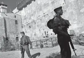  ??  ?? Israeli border police in January 2013 stand guard on the site known to Jews as the Tomb of the Patriarchs, and to Muslims as the Ibrahimi Mosque, in the West Bank city of Hebron. The UNESCO World Heritage committee on Friday put the city of Hebron on...