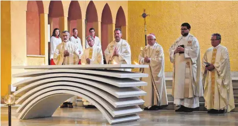  ?? FOTO: CHRISTEL VOITH ?? Altarweihe in St. Canisius: Fünf Feuer brennen auf dem Altar, Licht und Rauch steigen als Symbol der Gebete zu Gott empor. ANZEIGE