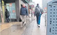  ?? JACK LAKEY ?? When it rains, a large puddle forms on the sidewalk on the east side of Yonge St., just north of Bloor St.