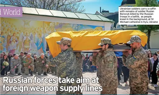  ?? ?? Ukrainian soldiers carry a coffin with remains of soldier Ruslan Borovyk killed by the Russian troops in a battle, as people kneel in the background, at St Michael cathedral in Kyiv, Ukraine