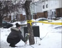  ?? Canadian Press photo ?? Local resident Jennifer Fuller places flowers at the scene outside of a house where a young girl was found dead in Brampton, Ont. on Friday,