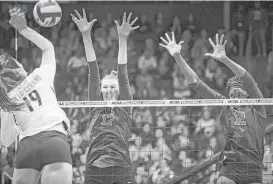  ?? Joshua A. Bickel / Tribune News Service ?? Stanford’s Merete Lutz, center, and Inky Ajanaku, right, rise to block a shot from Texas hitter Paulina Prieto-Cerame as the Cardinal roll to the title Saturday.