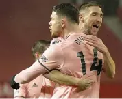  ?? — AP ?? Sheffield United’s Oliver Burke (left) is congratula­ted by teammate Chris Basham after scoring against Manchester United in their English Premier League match at Old Trafford in Manchester on Wednesday.