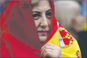  ?? AP/ENRIC MARTI ?? A woman covers her head with a Spanish flag Saturday as she attends a march against the referendum in downtown Barcelona, Spain.