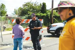  ?? Rebekah Welch/The Seattle Times via AP ?? ■ Police Officer Sam Lopez turns away would-be protesters Saturday in front of a roadblock near the Northwest Detention Center in Tacoma, Wash.