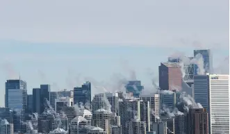  ?? GAVIN YOUNG ?? Steam rises from downtown Calgary buildings on a cold day this week. The executive offices of the oilpatch are still not as welcoming to women as some would expect by now, Deborah Yedlin writes.