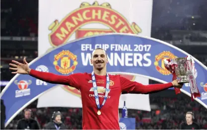  ??  ?? LONDON: Manchester United’s Zlatan Ibrahimovi­c celebrates with the trophy after his side won the League Cup Final soccer match by beating Southampto­n 3-2 at Wembley Stadium, London, Sunday. — AP