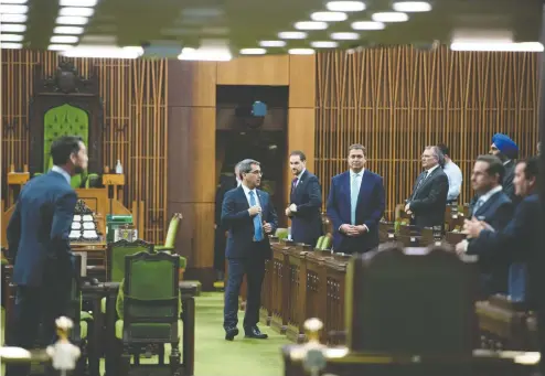  ?? JUSTIN TANG / THE CANADIAN PRESS ?? Conservati­ve MPs, including leader Andrew Scheer, wait for the Speaker’s parade to arrive, as a limited number of MPs returned
to the House of Commons on Tuesday to discuss measures to respond to the COVID-19 outbreak.