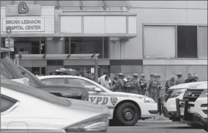  ?? The Associated Press ?? SHOOTING: Police gather outside Bronx Lebanon Hospital in New York after a gunman opened fire and then took his own life there on Friday. The gunman, identified as Dr. Henry Bello who used to work at the hospital, returned with a rifle hidden under his...