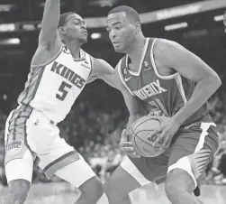  ?? MICHAEL CHOW/THE REPUBLIC ?? Suns forward T.J. Warren is defended by Kings guard De’Aaron Fox on Feb. 14 at Footprint Center in Phoenix.