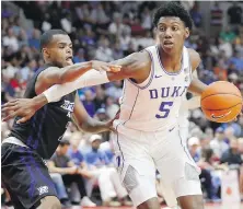  ??  ?? Duke Blue Devils forward and Canadian R.J. Barrett drives around Ryerson Rams forward Myles Charvis during exhibition action in Mississaug­a, Ont., on Wednesday. Barrett had 34 points in his debut for the NCAA powerhouse.