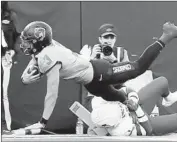  ?? Brody Schmidt Associated Press ?? OKLAHOMA STATE’S Spencer Sanders scores a touchdown over Iowa State’s Isheem Young.