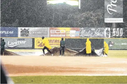  ??  ?? Una brigada de obreros se apresta a colocar la lona en el cuadro del Estadio Tetelo Vargas, de San Pedro de Macorís.