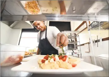  ?? Arnold Gold / Hearst Connecticu­t Media ?? Chef Ramon Rios puts the finishing touches on an artisan bruschetta at the Love Bakery and Cafe in Branford.