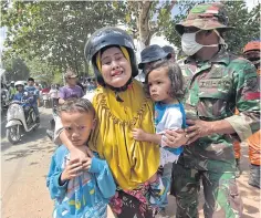  ?? AFP ?? An Indonesian woman cries as she holds onto her children shortly after an aftershock hit Tanjung on Lombok island yesterday.