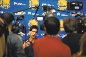  ?? Scott Strazzante / The Chronicle ?? Warriors general manager Bob Myers meets the media throng Monday to discuss Stephen Curry’s injury. The news: Curry has a grade 1 sprain of the MCL in his right knee.