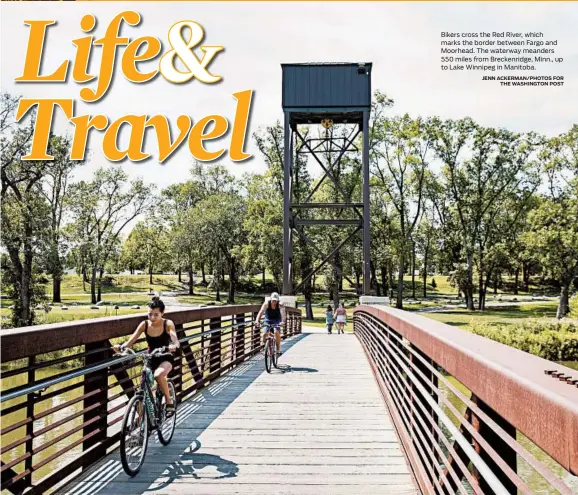  ?? JENN ACKERMAN/PHOTOS FOR THE WASHINGTON POST ?? Bikers cross the Red River, which marks the border between Fargo and Moorhead. The waterway meanders 550 miles from Breckenrid­ge, Minn., up to Lake Winnipeg in Manitoba.