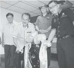  ??  ?? Datu Nasrun strikes the gong to declare open the roadshow. Also seen are (from left) Mawan and Mohd Chee.