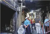  ?? Ahmed Ramzan/Gulf News ?? People in the lane leading up to the temple yesterday where two shops caught fire.