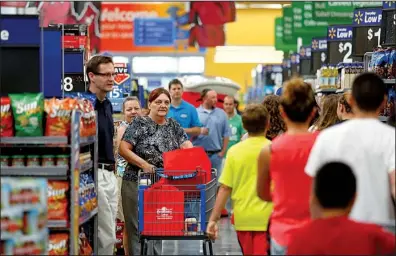  ?? NWA Media/JASON IVESTER ?? Shoppers crowd the aisles following the Aug. 13 grand opening of a Wal-Mart Supercente­r in Springdale.