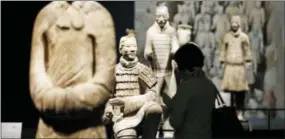  ?? STEVE HELBER — THE ASSOCIATED PRESS ?? In a Tuesday photo, visitors look over some of the Terracotta Army soldiers on exhibit at the Virginia Museum of Fine Arts in Richmond, Va. The Museum has 10 of the majestic terracotta figures on display as part of an exhibit that tells the story of...