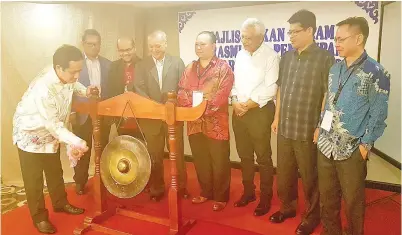  ??  ?? KAMARUDIN (kiri) menyempurn­akan gimik perasmian penutupan Seminar Bencana Alam.