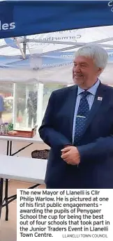  ?? LLANELLI TOWN COUNCIL ?? The new Mayor of Llanelli is Cllr Philip Warlow. He is pictured at one of his first public engagement­s – awarding the pupils of Penygaer School the cup for being the best out of four schools that took part in the Junior Traders Event in Llanelli Town Centre.