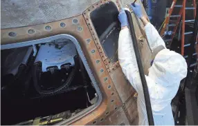  ?? JAY REEVES/AP ?? Gary Phillips uses a brush and a vacuum to clean the Apollo 16 lunar spacecraft at the U.S. Space and Rocket Center in Huntsville, Ala., on Feb. 1. The museum is sprucing up the antique spaceship before events marking the 50th anniversar­y of its flight in 1972.