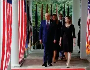  ?? AP- Alex Brandon ?? President Donald Trump walks along the Colonnade with Judge Amy Coney Barrett to a news conference to announce Barrett as his nominee to the Supreme Court, in the Rose Garden at the White House, Saturday, in Washington. Georgia senators are divided over Trump’s pick.