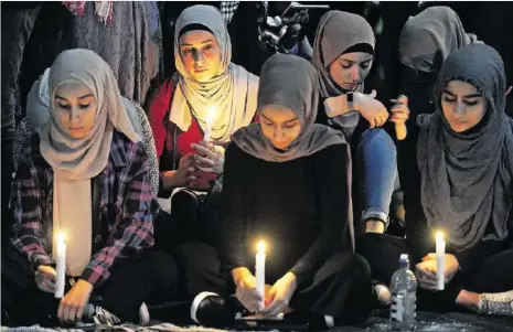  ?? GETTY ?? Mit Kerzen trauern diese Frauen um die Opfer des Anschlags, die mutmasslic­h alle muslimisch­en Glaubens waren.