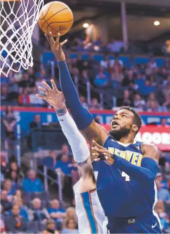  ?? The Associated Press ?? Nuggets forward Paul Millsap tries to score against the Thunder during Friday’s game in Oklahoma City. Millsap contribute­d 36 points to Denver’s road trip-ending, 126-125 victory.