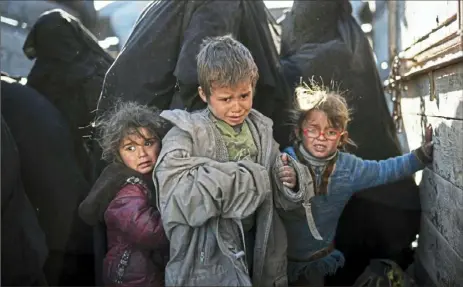  ?? Felipe Dana/Associated Press ?? Women and children step out of a truck Friday as they arrive at a U.S.-backed Syrian Democratic Forces screening area. They were evacuated out of the last territory held by Islamic State group militants in the desert outside Baghouz, Syria.