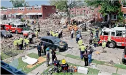  ?? AP ?? Rescue officials work near the rubble in the aftermath of an explosion in Baltimore, on Monday. Baltimore firefighte­rs say an explosion has leveled several homes in the city. —
